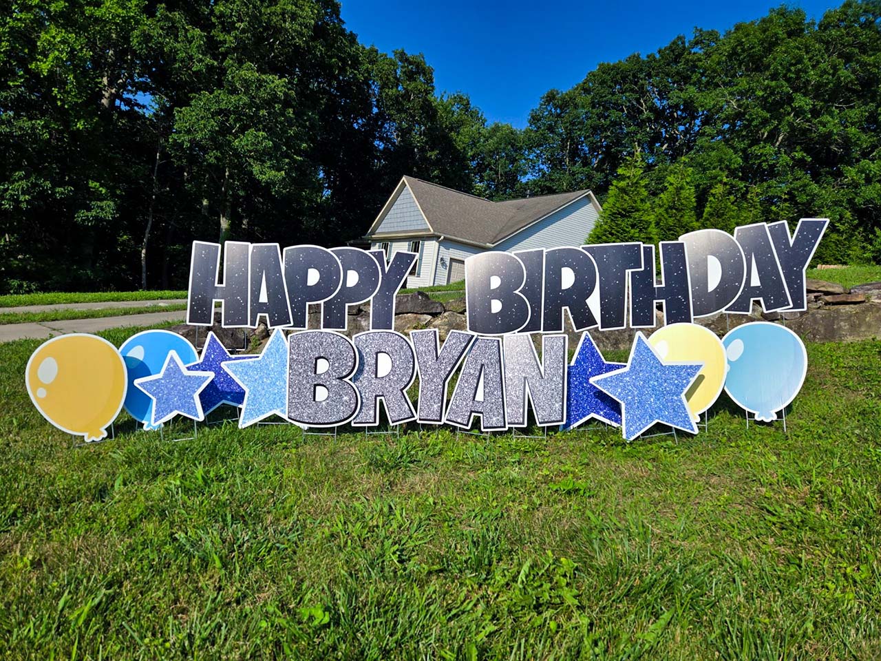 Example of a birthday greeting that reads 'Happy Birthday Bryan' and has blue and yellow balloons and blue stars