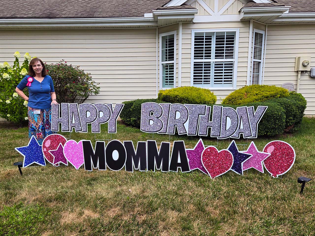 Example of a birthday greeting that reads 'Happy Birthday Momma' with blue, red, purple, and pink stars and balloons